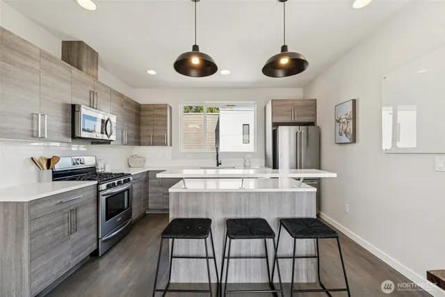 a kitchen with stainless steel appliances kitchen island granite countertop a stove a sink and a microwave
