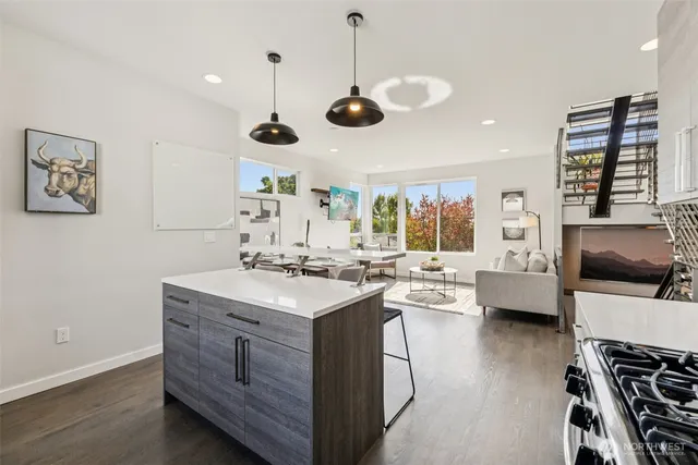 a kitchen with a stove a window and chairs