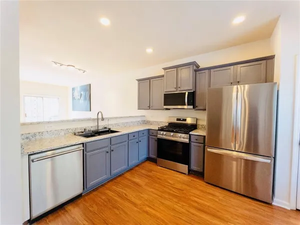 a kitchen with granite countertop stainless steel appliances and wooden cabinets