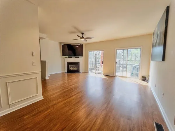 a view of an empty room with window and wooden floor
