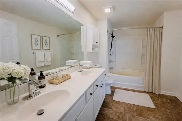 a spacious bathroom with a tub sink and mirror