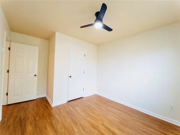 a view of empty room with wooden floor