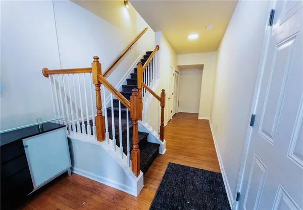 a view of entryway and hall with wooden floor