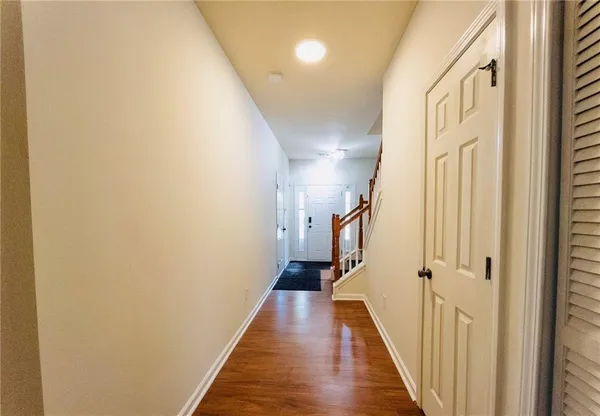 a view of a hallway with wooden floor and staircase