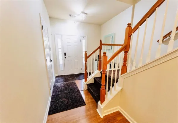 a view of a hallway with wooden floor and staircase