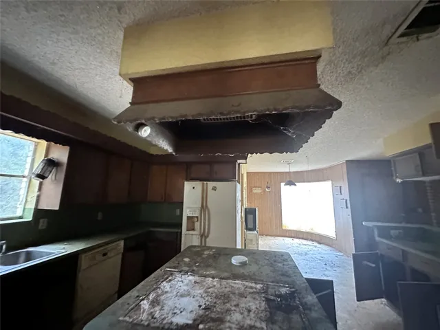 a kitchen with stainless steel appliances kitchen island granite countertop a refrigerator and a stove