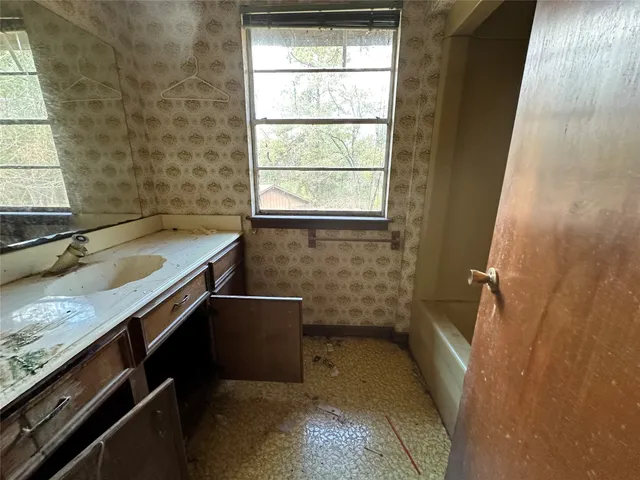 a view of a bedroom with wooden floor and a window