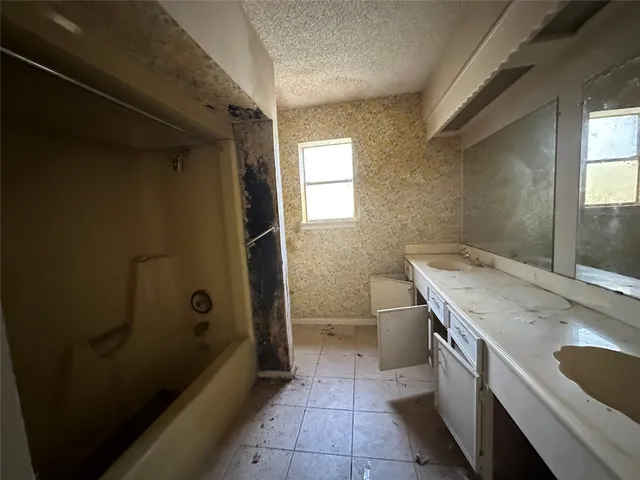 a bathroom with a granite countertop sink a toilet and shower