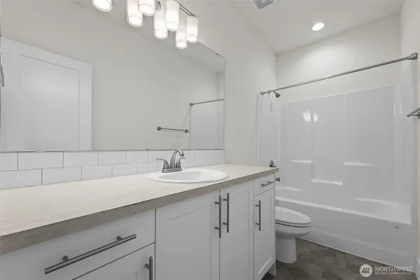 a bathroom with a granite countertop sink a toilet and shower