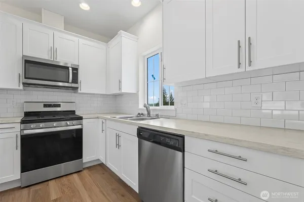 a kitchen with cabinets stainless steel appliances a sink and a stove