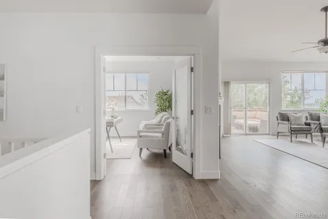 a view of a bedroom with wooden floor and furniture