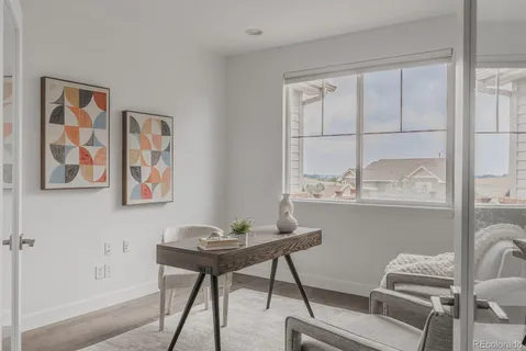 a view of a workspace with furniture and a window