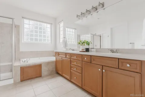 a spacious bathroom with a double vanity sink bathtub and next to a window