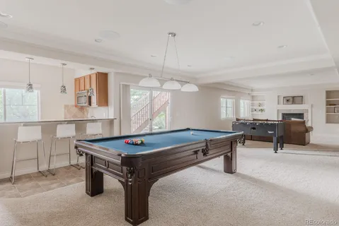 a room with furniture pool table and windows