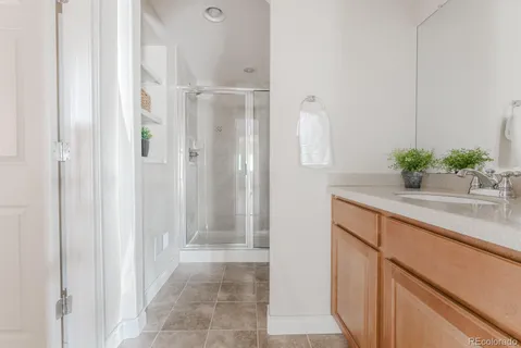 a bathroom with a granite countertop sink a mirror and shower
