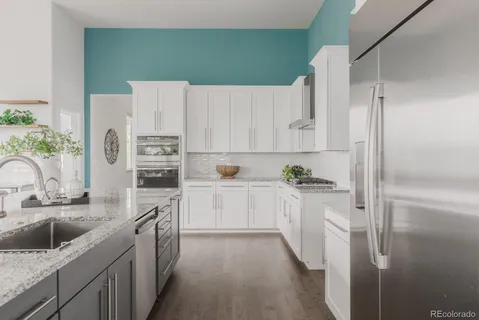 a kitchen with white cabinets and stainless steel appliances