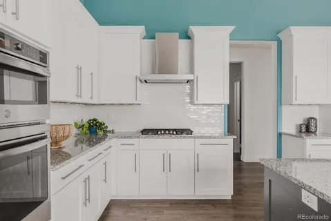 a kitchen with stainless steel appliances white cabinets and a refrigerator