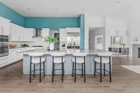 a kitchen with a dining table chairs and sink
