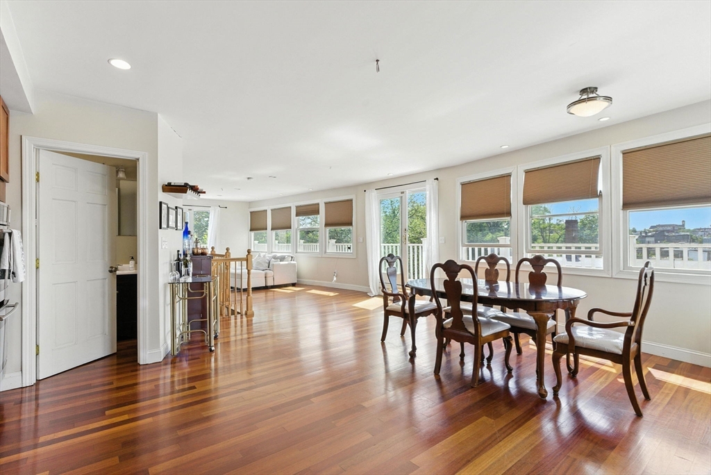 a dining room with furniture window and wooden floor