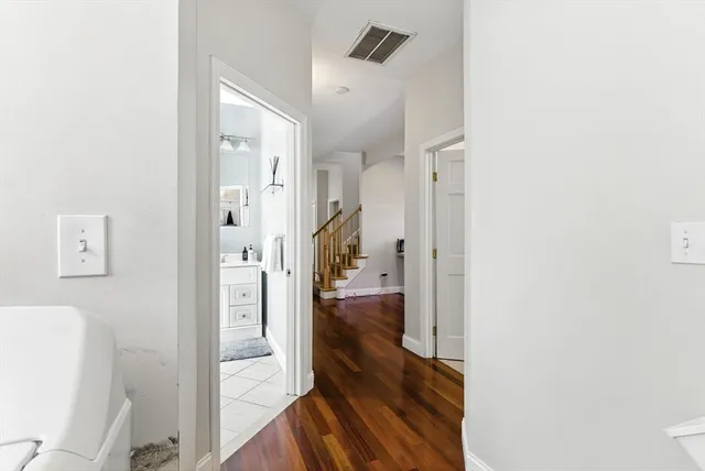 a view of a hallway with wooden floor and dining room view