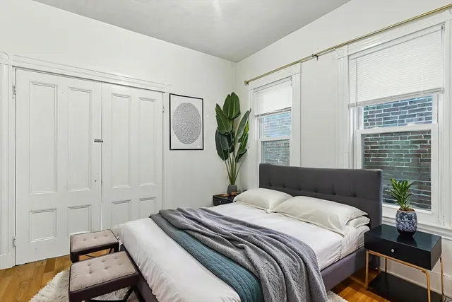 a bedroom with a bed table and a window