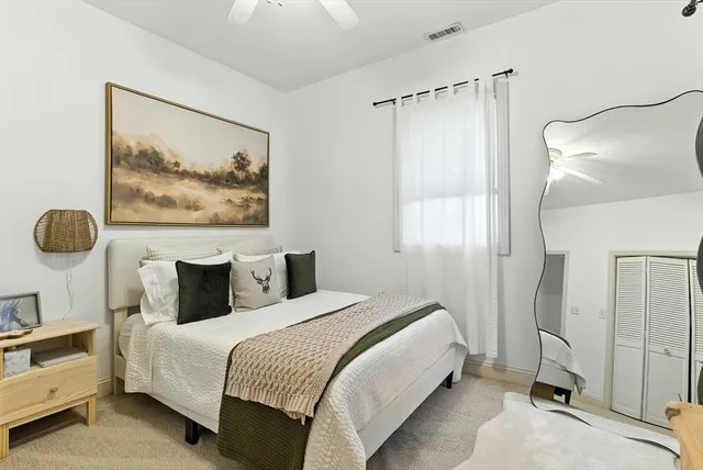 a bedroom with a bed and a painting on the wall