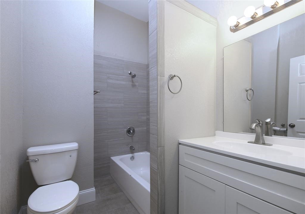 4445 Rusk Street Houston, TX 77023 - Photo 15 of 50 Unit #1 full bath with recent new vanities, new light fixtures, new tub/shower combo, new toilet, floors, and tile.
