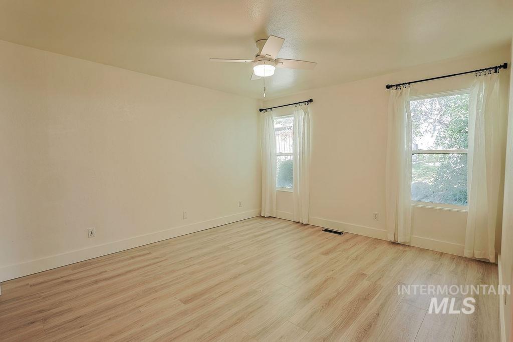 640 Morrison Street Twin Falls, ID 83301 - Photo 16 of 30 Spacious room featuring light wood-finish flooring, a ceiling fan with integrated lighting, and two large windows with white trim