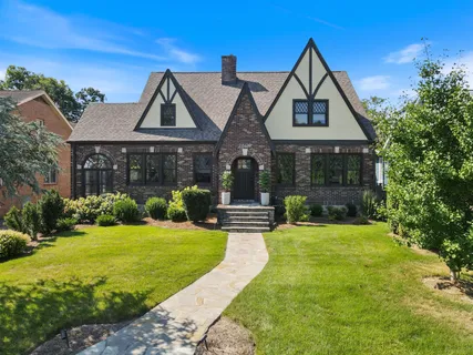 a front view of a house with yard and green space