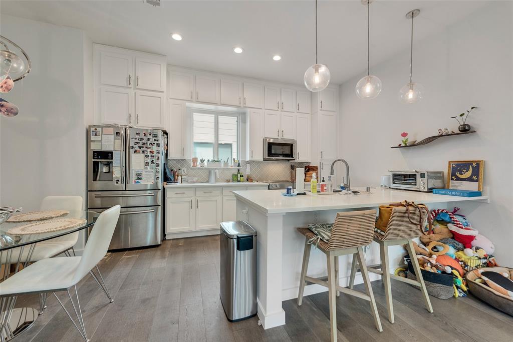 6004 Hudson Street, Unit 102 Dallas, TX 75206 - Photo 10 of 22 a kitchen with stainless steel appliances granite countertop a sink a stove a refrigerator cabinets and chairs