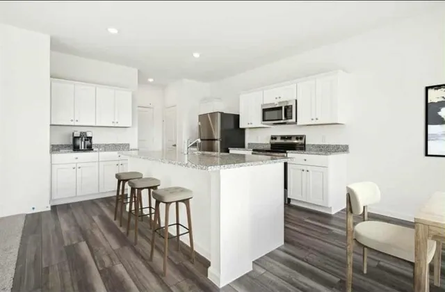 a kitchen with white cabinets and appliances