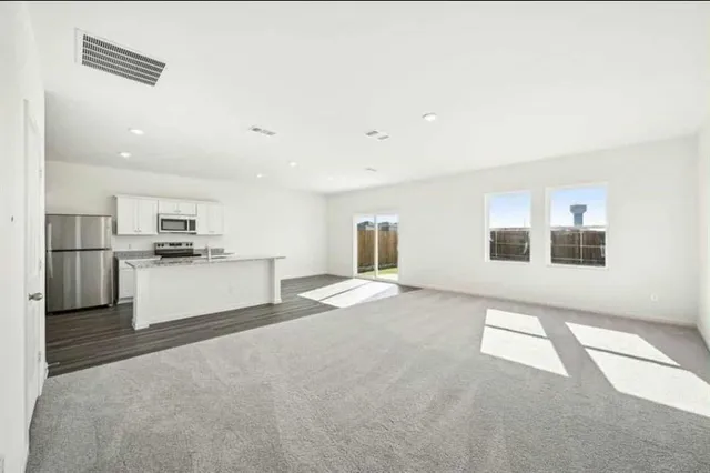 a view of a kitchen with kitchen island a sink wooden floor and counter top space