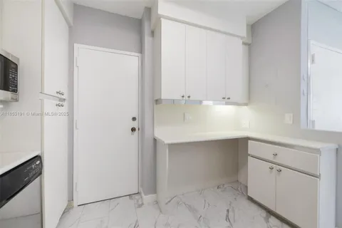 a room view with wooden floor and cabinets