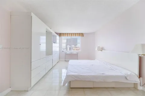 a spacious bedroom with a bed and a cabinets