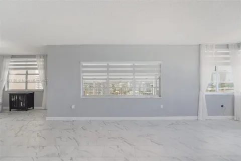 an empty room with windows and fireplace