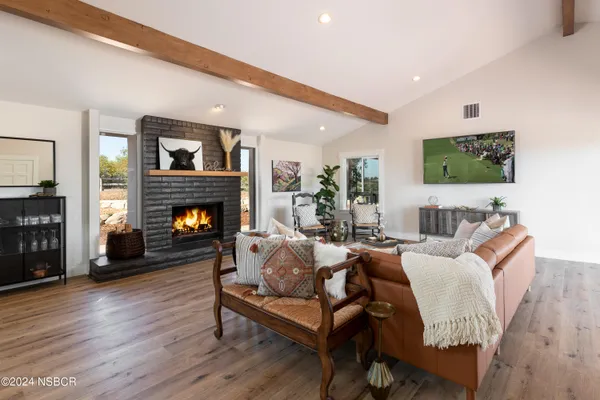 a living room with furniture a flat screen tv and a fireplace