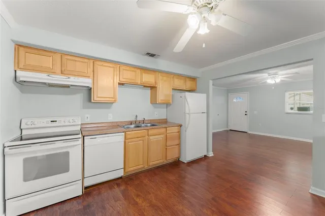a kitchen with cabinets wooden floor and a window