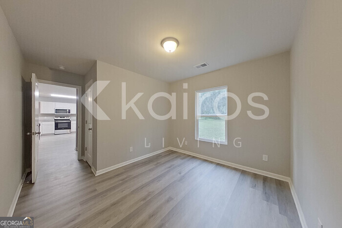 236 Sunrise Circle Midway, GA 31320 - Photo 11 of 31 a view of empty room with wooden floor and fan