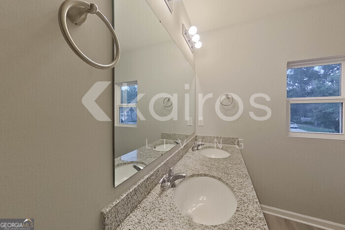236 Sunrise Circle Midway, GA 31320 - Photo 24 of 31 a bathroom with a granite countertop sink a mirror and a shower