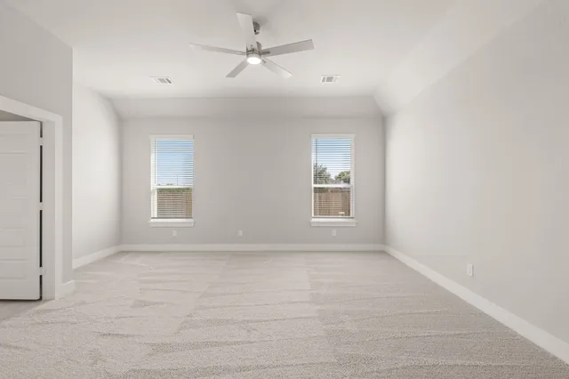 an empty room with windows and fan