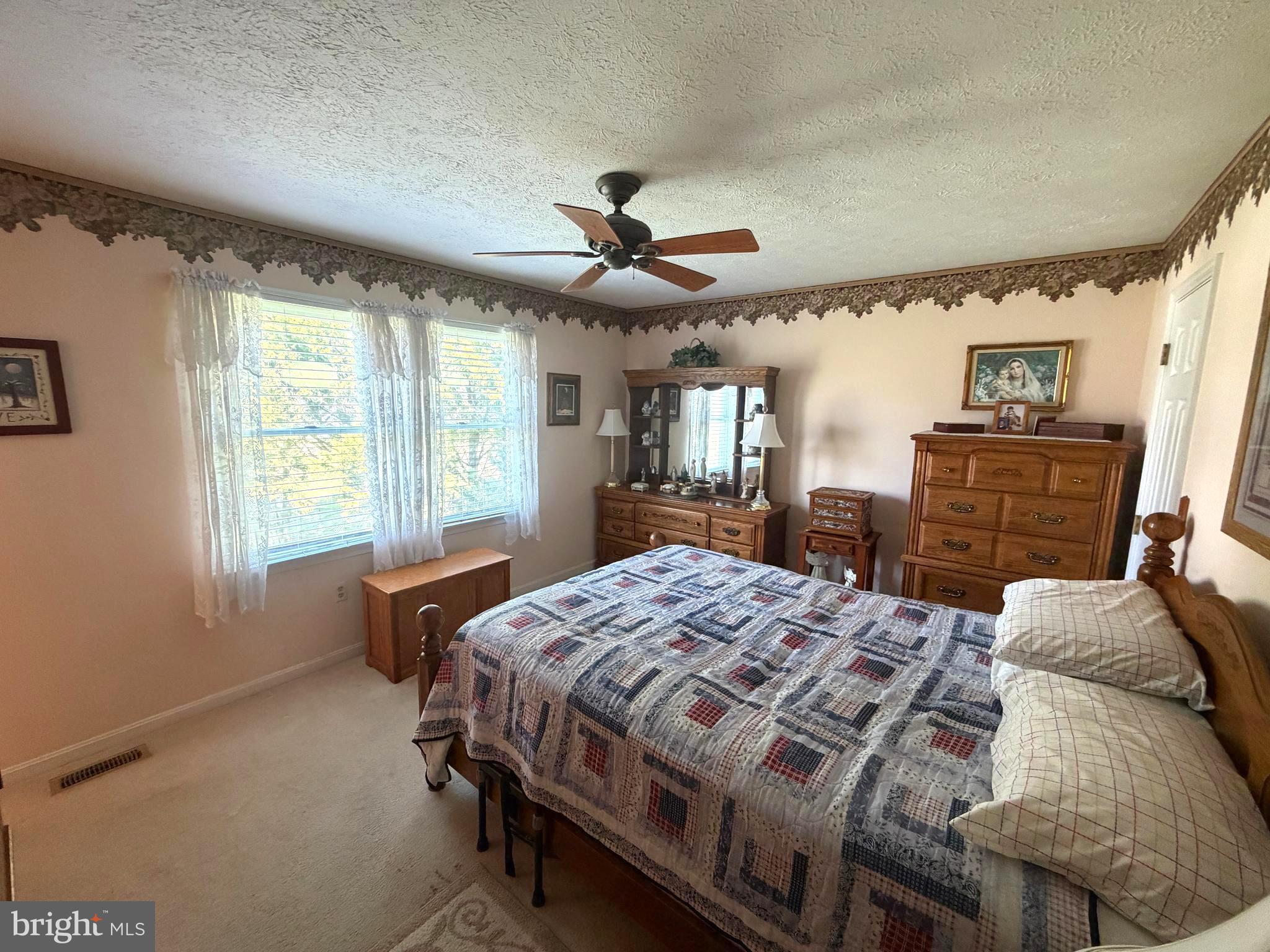 945 Firetower Road Colora, MD 21917 - Photo 14 of 29 a bedroom with a bed a dresser and a chandelier