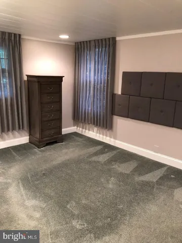 a view of an empty room with wooden cabinet