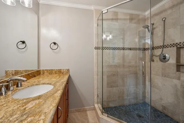 a bathroom with a granite countertop shower sink and mirror