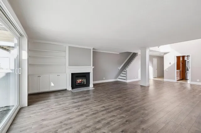 a view of a livingroom with wooden floor and fireplace
