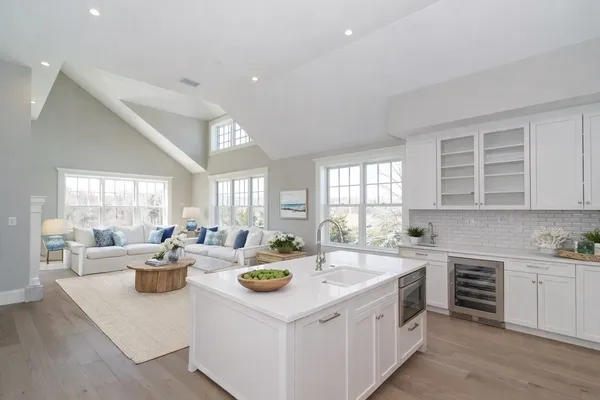 a view of a kitchen with kitchen island a sink a stove a cabinets and a window