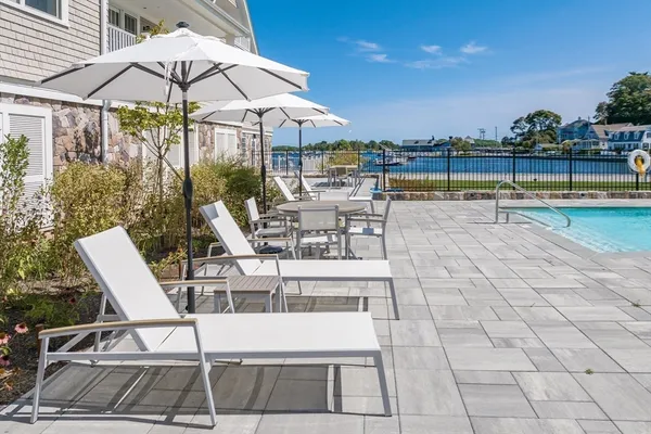 a view of a swimming pool with a table and chairs under an umbrella