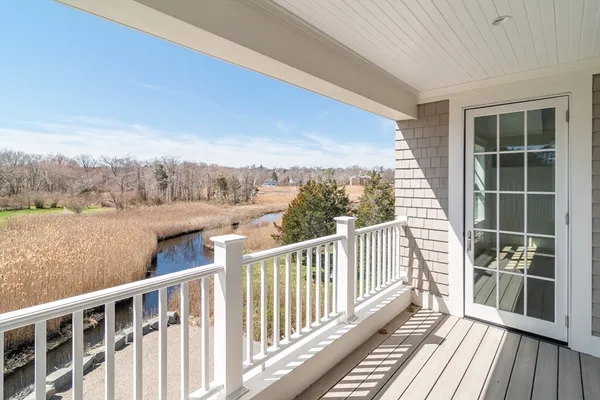 a view of a balcony with wooden floor and fence