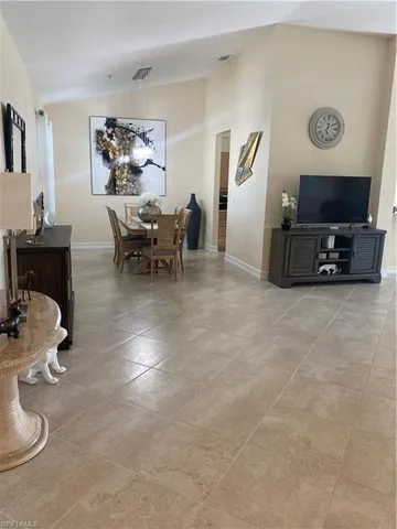 a living room with furniture a flat screen tv and a table