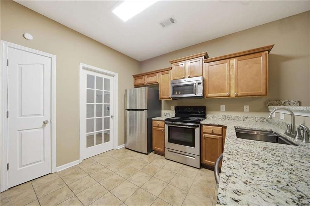 3834 Augustine Place Rex, GA 30273 - Photo 11 of 41 a kitchen with stainless steel appliances granite countertop a stove a sink and a refrigerator