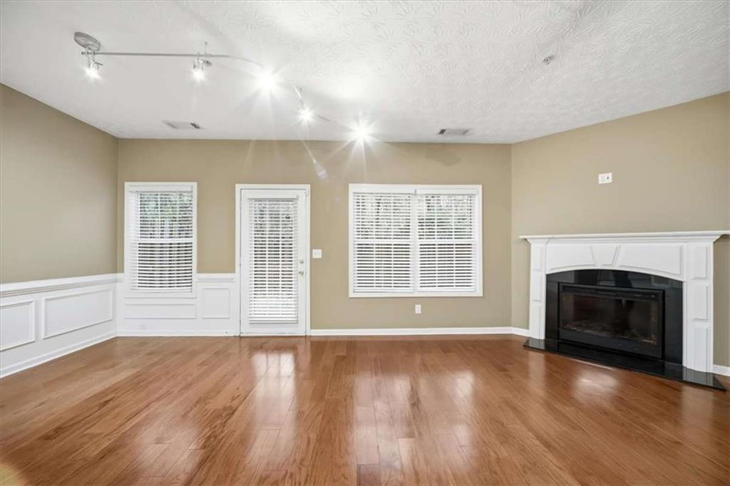 3834 Augustine Place Rex, GA 30273 - Photo 14 of 41 an empty room with wooden floor fireplace and windows